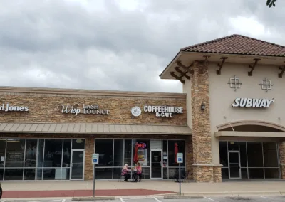 The front of a store with cars parked in front of it.